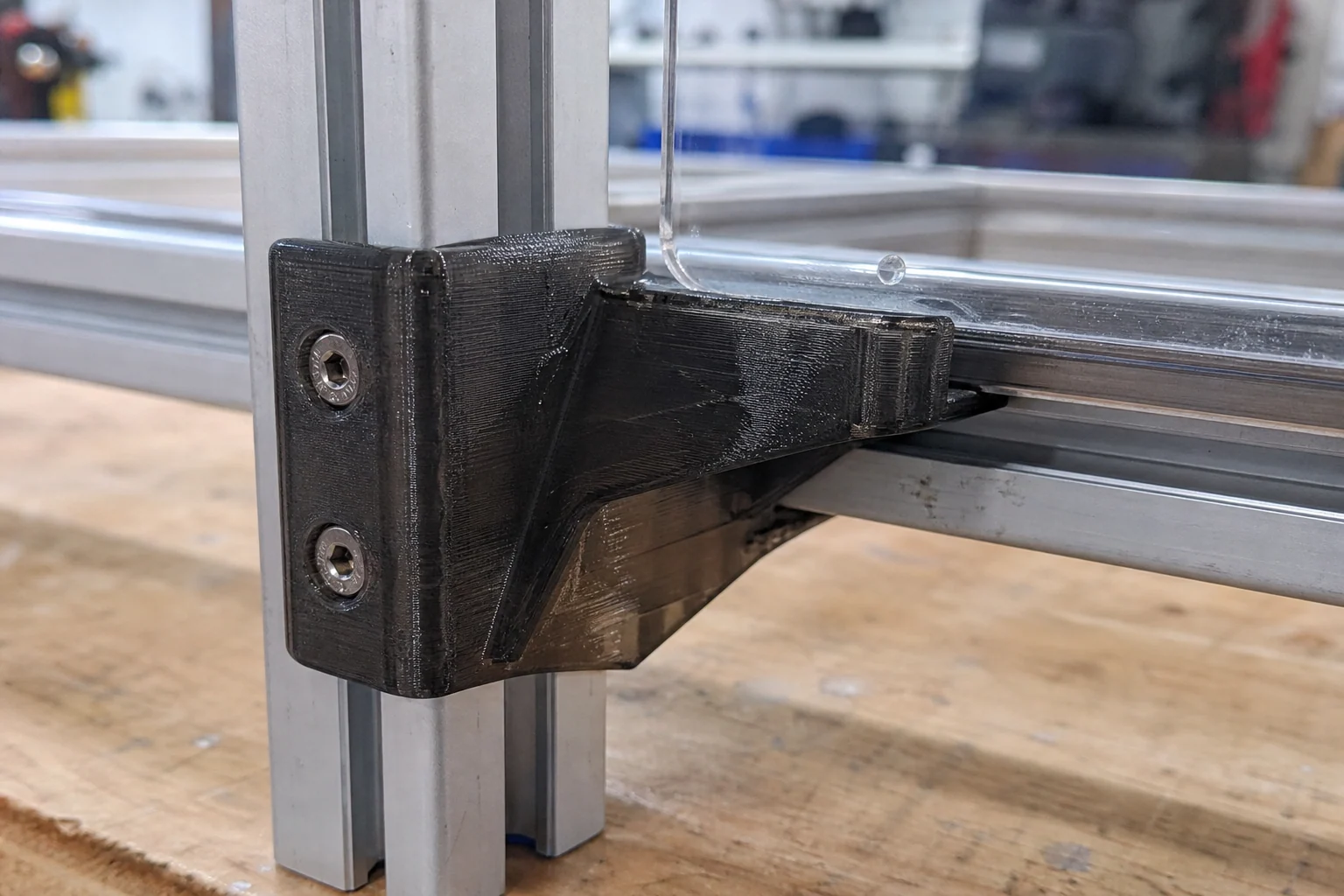 Smoke-black PETG mounting bracket installed on an aluminum extrusion test fixture